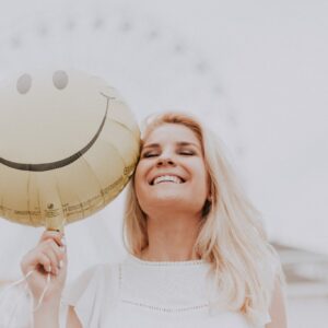 Woman Holding a Smiley Balloon